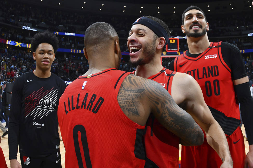 From front, Portland Trail Blazers guard Damian Lillard celebrates with guard Seth Curry and ce ...
