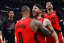 From front, Portland Trail Blazers guard Damian Lillard celebrates with guard Seth Curry and ce ...