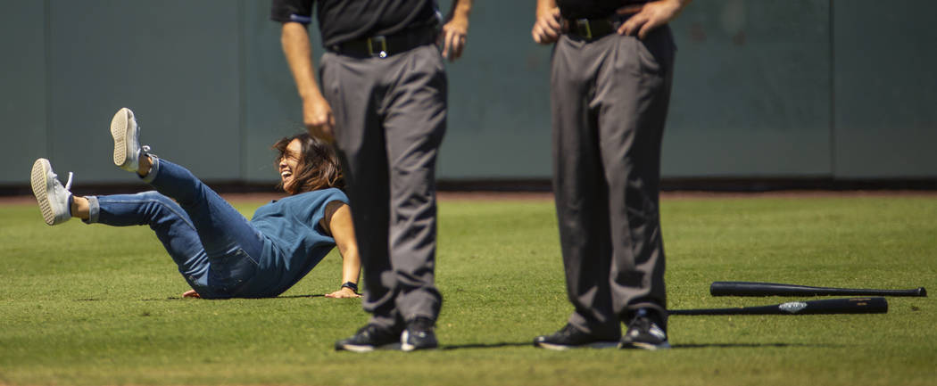 An Aviators fan falls down during a dizzy bat race with her daughter during a break in the acti ...