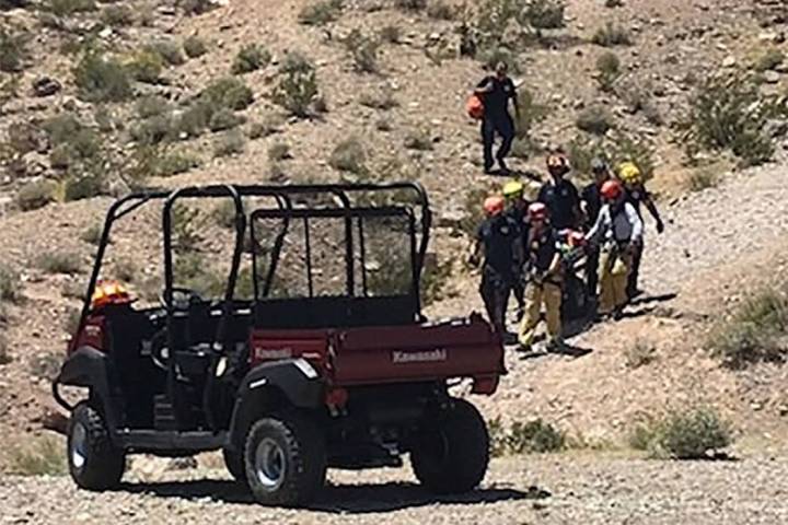 Rescuers carry a sick hiker down Lone Mountain in Las Vegas on Sunday, May 12, 2019. (Las Vegas ...
