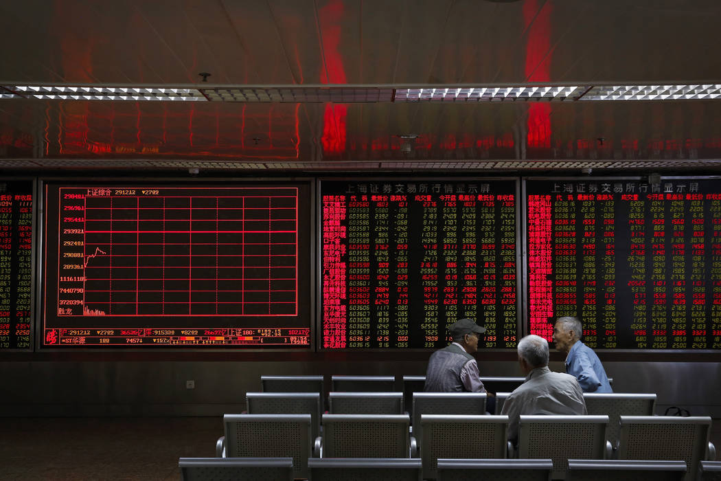 Chinese investors chat as they monitor stock prices at a brokerage house in Beijing, Monday, Ma ...
