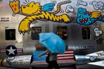 A woman walks by a bench painted with an American flag outside a fashion boutique selling U.S. ...
