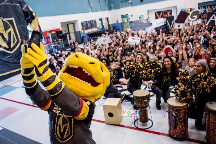 Vegas Golden Knights mascot Chance the Gila monster takes a selfie with the crowd during a Gold ...