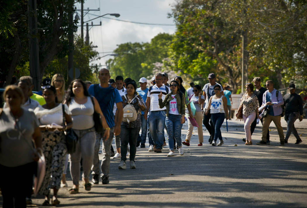 In this April 26, 2019, photo, Cubans wait their turn to enter Panama's embassy to apply for tr ...