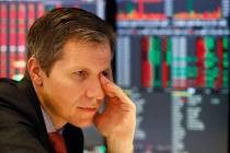 Market maker Thomas Brown follows stock prices at the New York Stock Exchange, Monday, May 13, ...