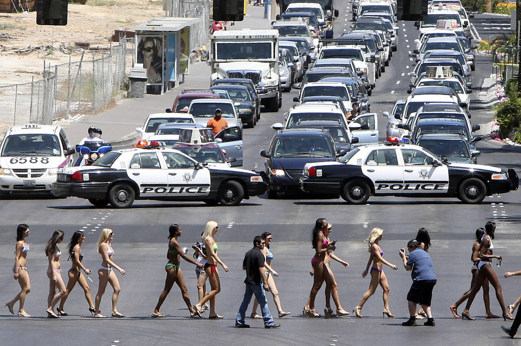 Bikini-clad women stop traffic with a little aid from the Las Vegas police as they form the wor ...