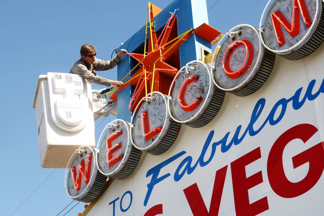 YESCO sign serviceman Kenny West examines the neon on the iconic "Welcome to Fabulous Las Vegas ...