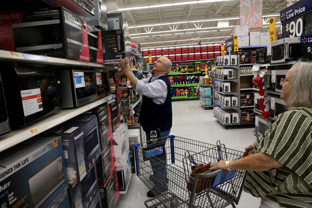 Assistant Manager James Hutchinson helps Diane Campbell of Henderson with a purchase at Walmart ...