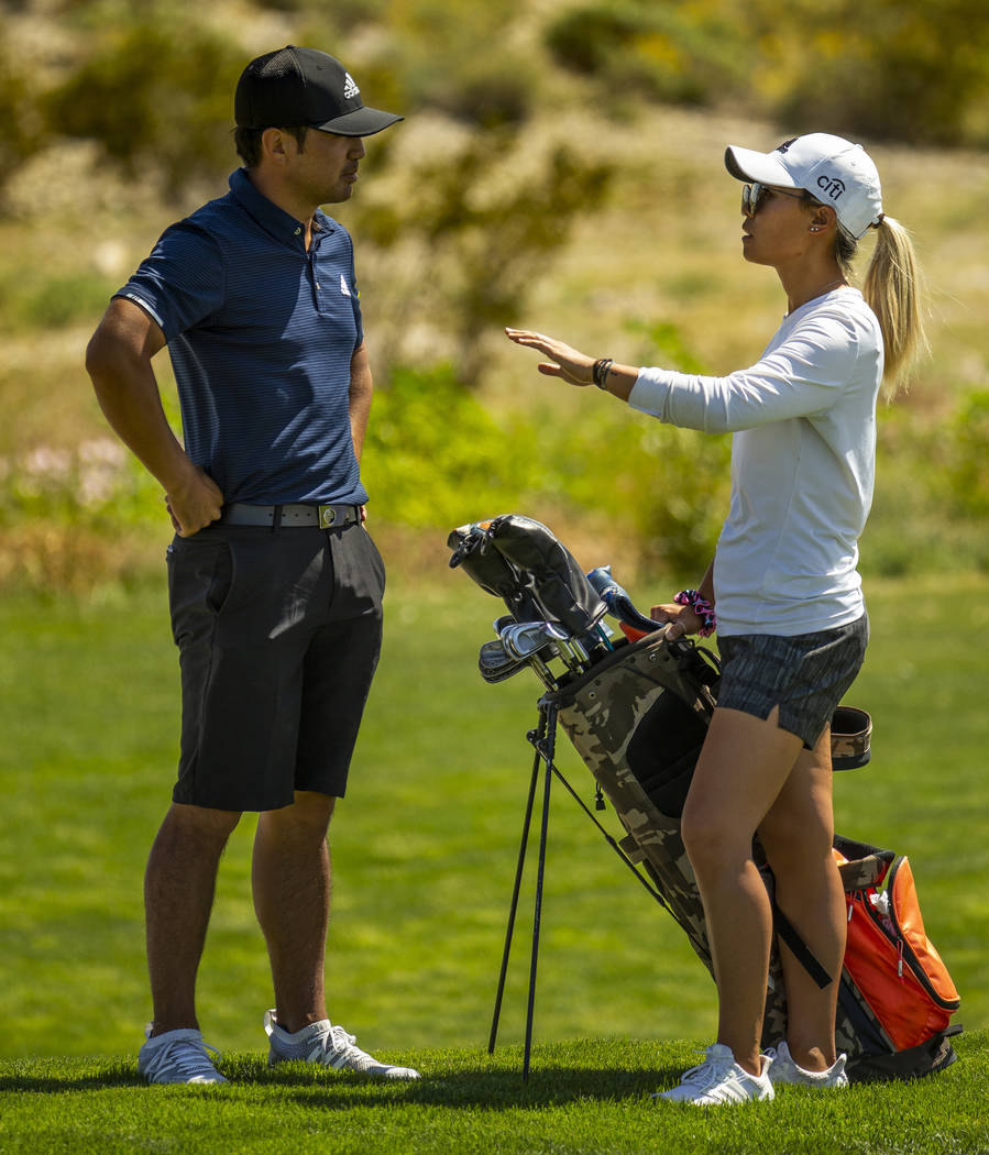 Golfer Alexander Kang listens to his sister and caddy LPGA golfer Danielle Kang on the course d ...