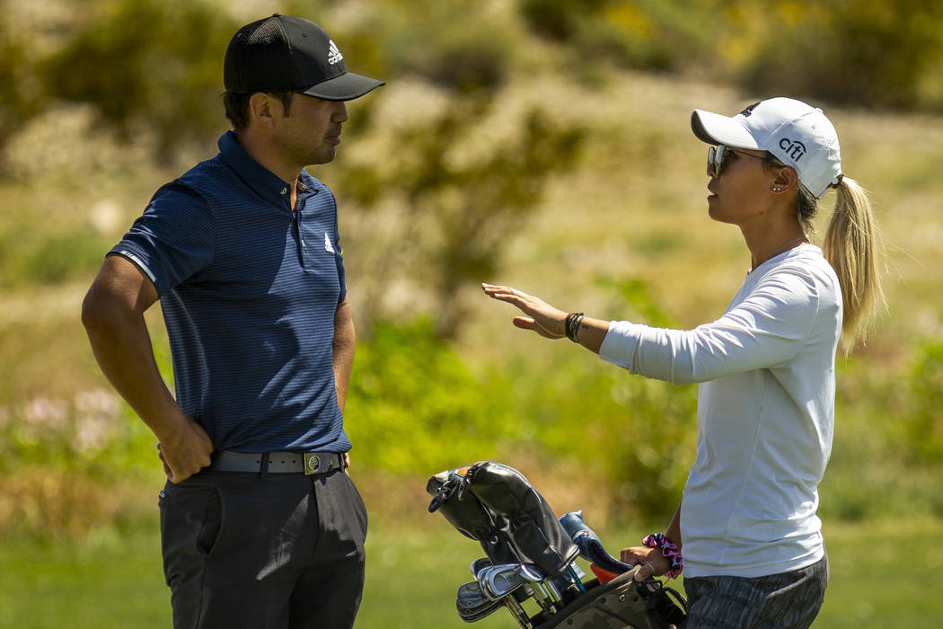Golfer Alexander Kang listens to his sister and caddy LPGA golfer Danielle Kang on the course d ...