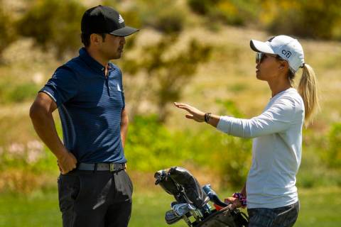 Golfer Alexander Kang listens to his sister and caddy LPGA golfer Danielle Kang on the course d ...
