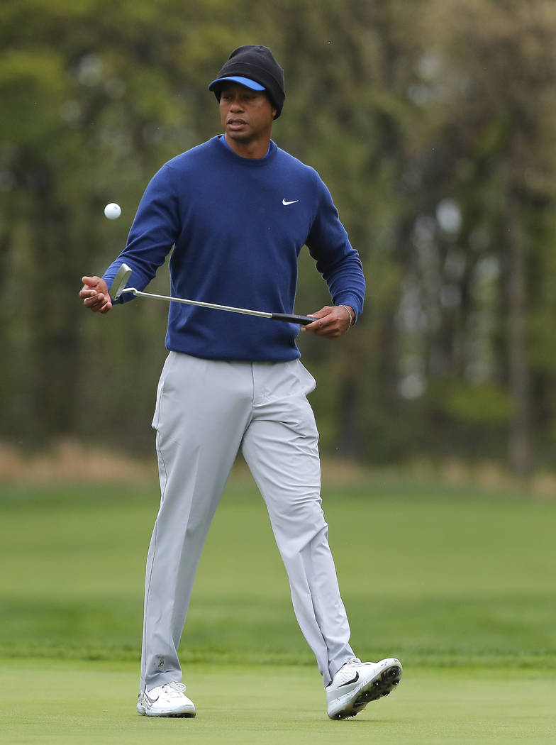 Tiger Woods flips his ball as he walks along the ninth green during a practice round for the PG ...
