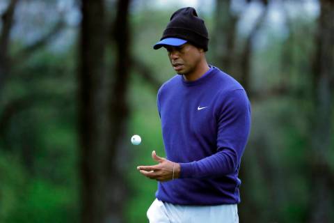 Tiger Woods flips his ball as he walks along the ninth green during a practice round for the PG ...