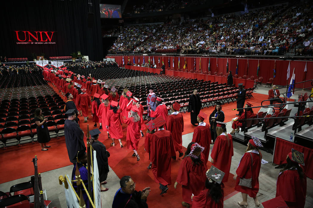 Graduates attend the UNLV commencement ceremony at the Thomas & Mack Center in Las Vegas, S ...