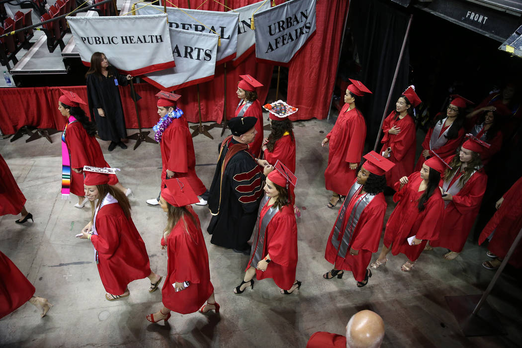 Graduates attend the UNLV commencement ceremony at the Thomas & Mack Center in Las Vegas, S ...