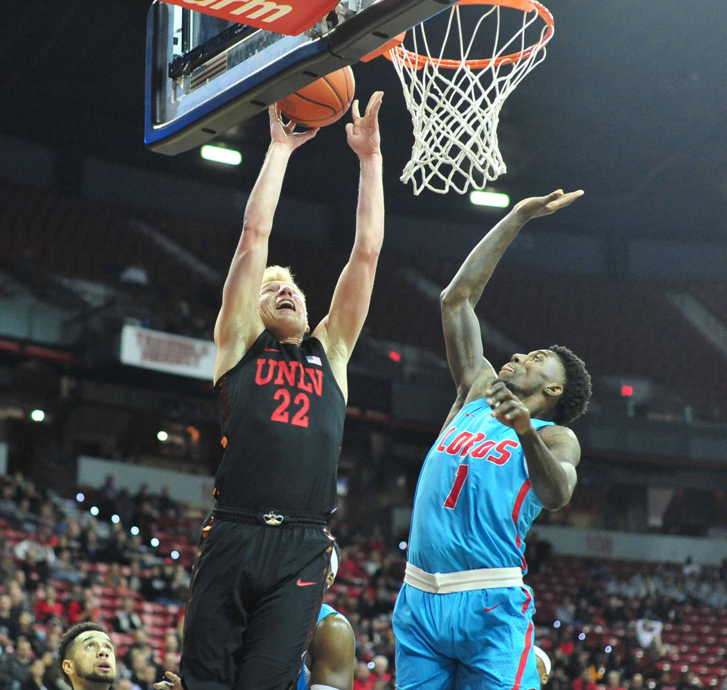 UNLV Rebels guard Trey Woodbury (22) shoots the ball over New Mexico Lobos forward Corey Maniga ...