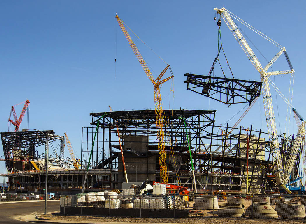 The newest truss is slowly lowered and attached into place at the top of Raiders Stadium on Wed ...