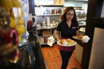 Lita Harris runs food to customers during lunch at Archi's Thai Bistro in Las Vegas, Thursday, ...