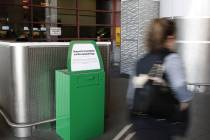 A passenger walks past a recently installed marijuana amnesty drop box at McCarran Internationa ...