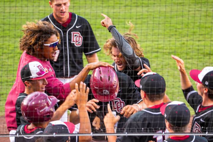 Desert Oasis players congratulate Parker Schmidt (4), center, on another run against Reno duri ...