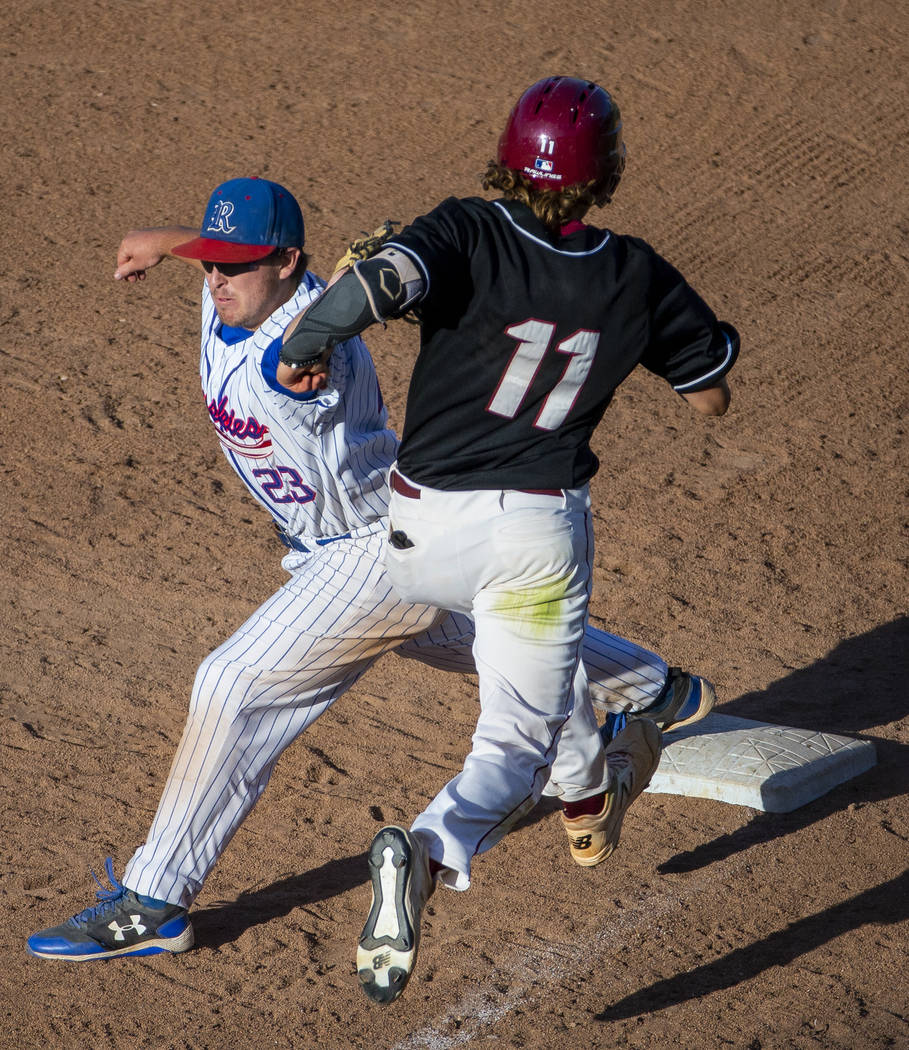 Reno's Ryan Hess (23) attempts a tag on Desert Oasis runner Josh Sharman (11) but will bobble t ...