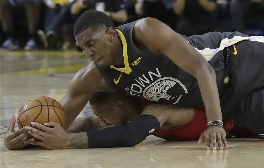 Golden State Warriors center Kevon Looney, top, reaches for the ball over Portland Trail Blazer ...
