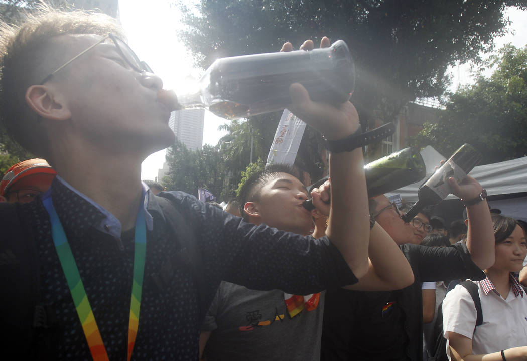 Same-sex marriage supporters cheer with a toast outside the Legislative Yuan Friday, May 17, 20 ...