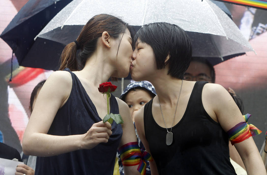 Same-sex marriage supporters kiss outside the Legislative Yuan Friday, May 17, 2019, in Taipei, ...