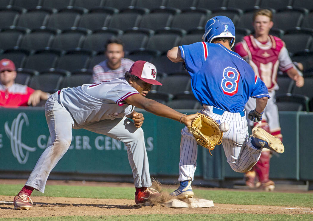 Desert Oasis' Jacob Walsh (21) receives the ball late though Reno runner Gunner Gouldsmith (8) ...