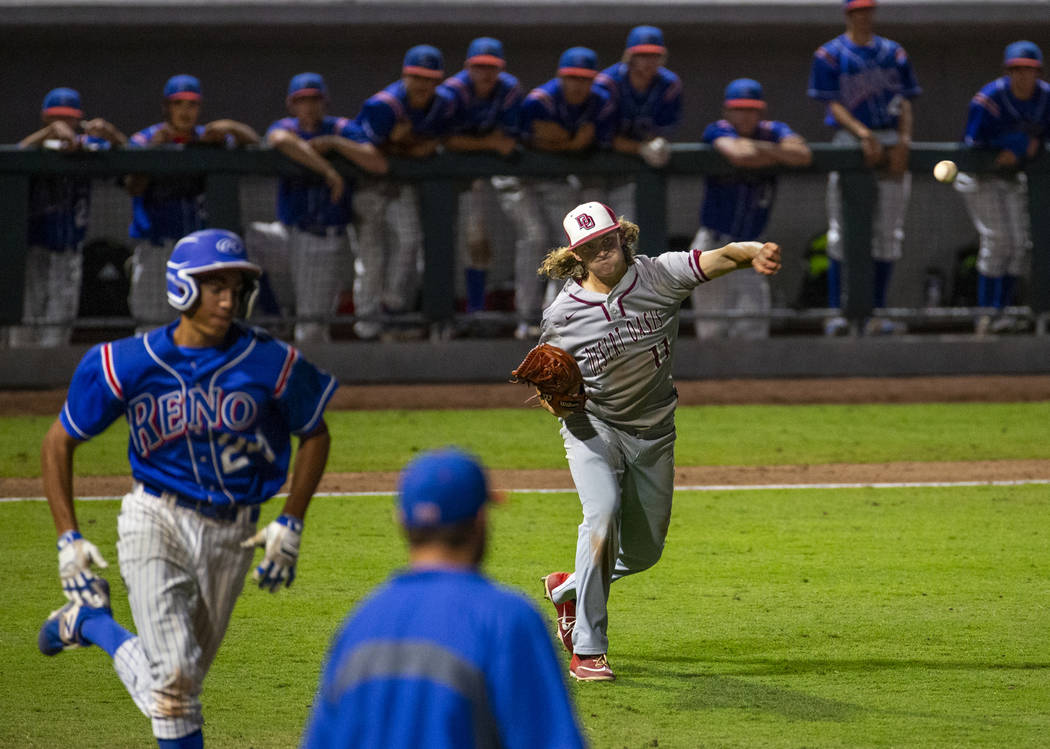 Desert Oasis pitcher Josh Sharman (11, right) throws the final out to first base ahead of Reno ...