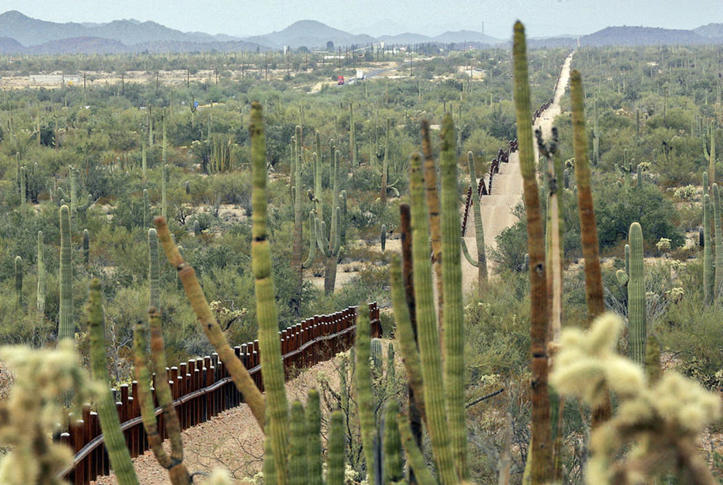 A fence separating Organ Pipe Cactus National Monument, right, and Sonyota, Mexico, is seen run ...
