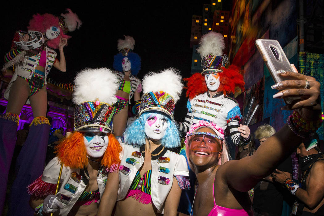Liz Wright, of Chicago, records with her phone while posig with a group of costumed perfomers d ...