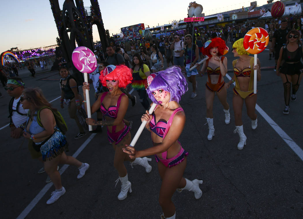 Costumed performers walk by during the first day of the Electric Daisy Carnival at the Las Vega ...