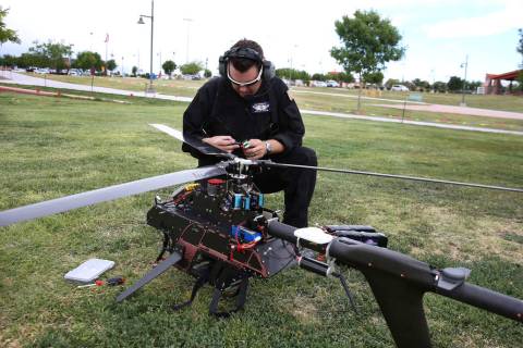 Jason Daub, a pilot in command, inspects before flying the Vapor 55 unmanned helicopter over Cr ...