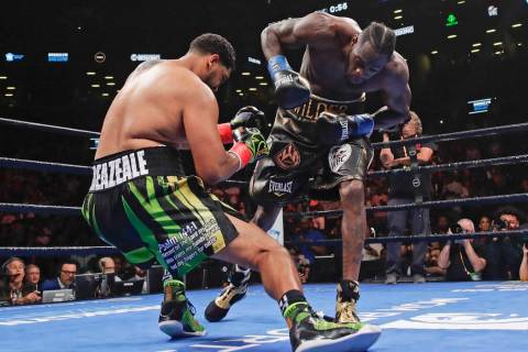Deontay Wilder, right, knocks down Dominic Breazeale during the first round of the WBC heavywei ...