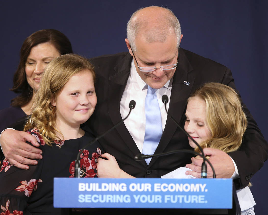 Australian Prime Minister Scott Morrison, center, embraces his daughters Lily, right, and Abbey ...