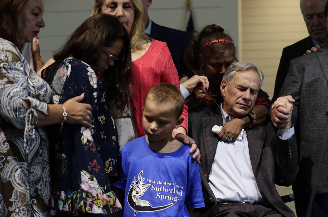Texas Gov. Greg Abbott, right, holds hands with survivors during a dedication ceremony for a ne ...