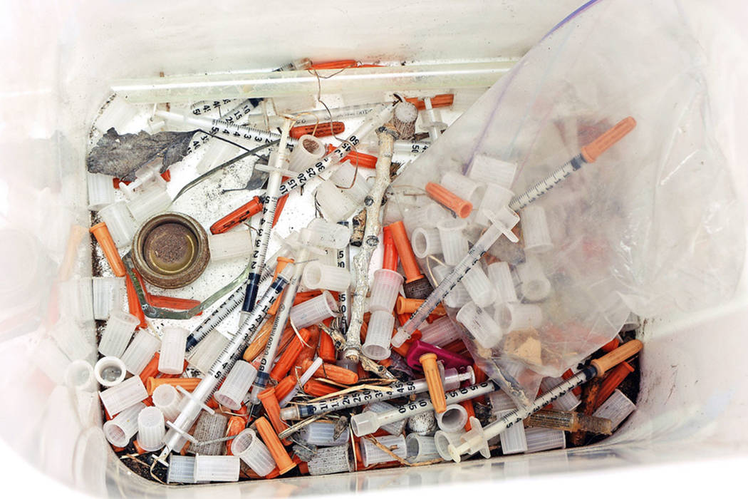 This photo shows hypodermic needles, needle caps, cotton swabs and other drug paraphernalia rem ...