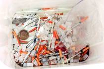 This photo shows hypodermic needles, needle caps, cotton swabs and other drug paraphernalia rem ...