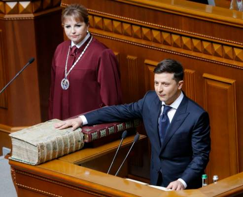 Ukrainian President-elect Volodymyr Zelenskiy swears on the Bible as he takes the oath of offic ...