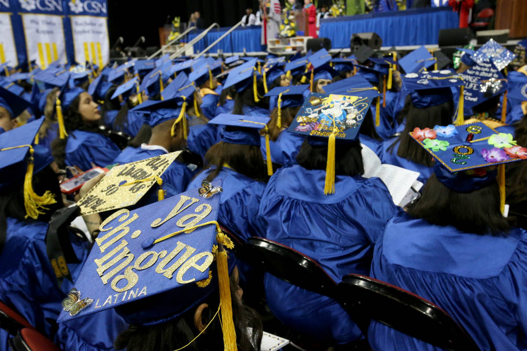 Graduates, including Rosario Hernandez, left, don personalized mortarboards during College of S ...