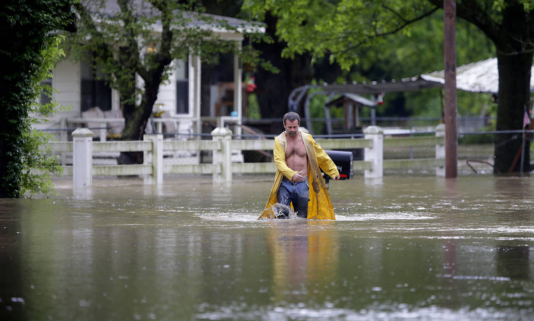 David Dick wades out of the water after checking on his flooded home in Sperry, Okla., Tuesday, ...