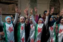 Anti-Syrian regime protesters flash the victory sign Dec. 21, 2011, as they wear Syrian revolut ...