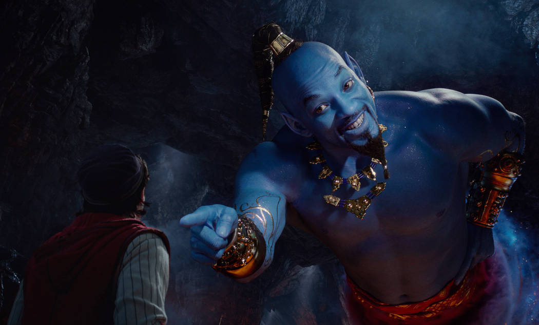 This image released by Disney shows Mena Massoud as Aladdin, left, and Will Smith as Genie in D ...