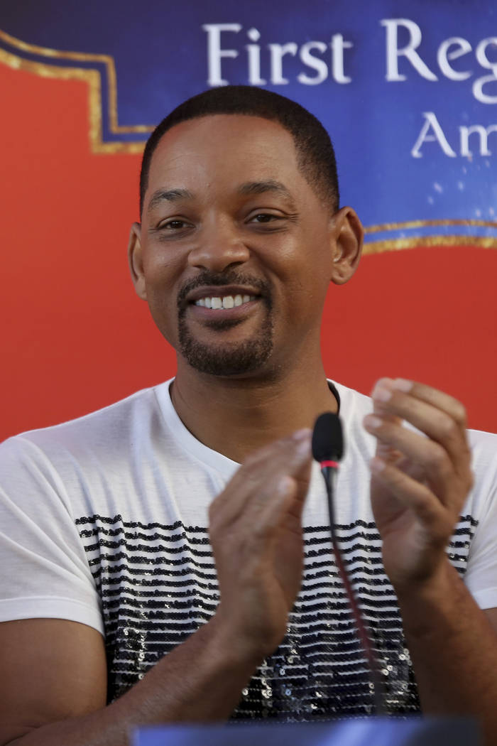 U.S. actor Will Smith applauds during a news conference with the director Guy Ritchie and stars ...