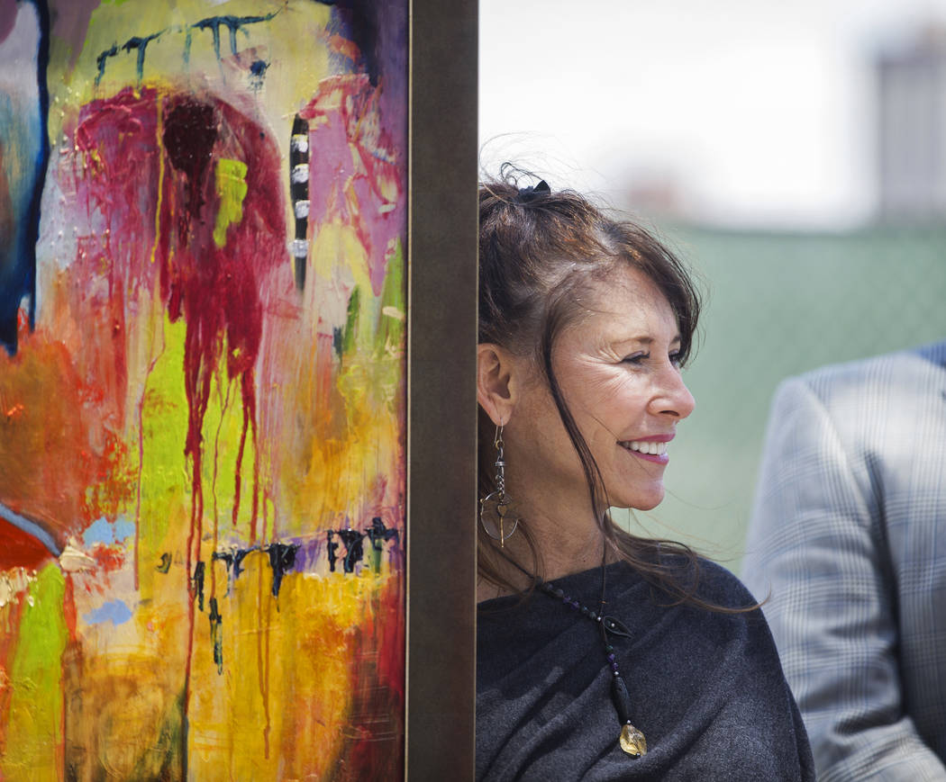 Artist Niki Sands stands next to one of her paintings during a ground breaking ceremony for the ...