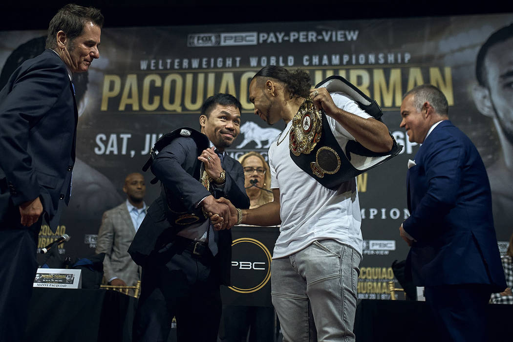 Manny Pacquiao, center left, shakes hands with Keith Thurman, center right, during a news confe ...