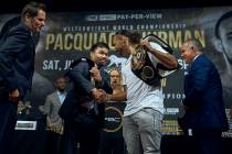 Manny Pacquiao, center left, shakes hands with Keith Thurman, center right, during a news confe ...