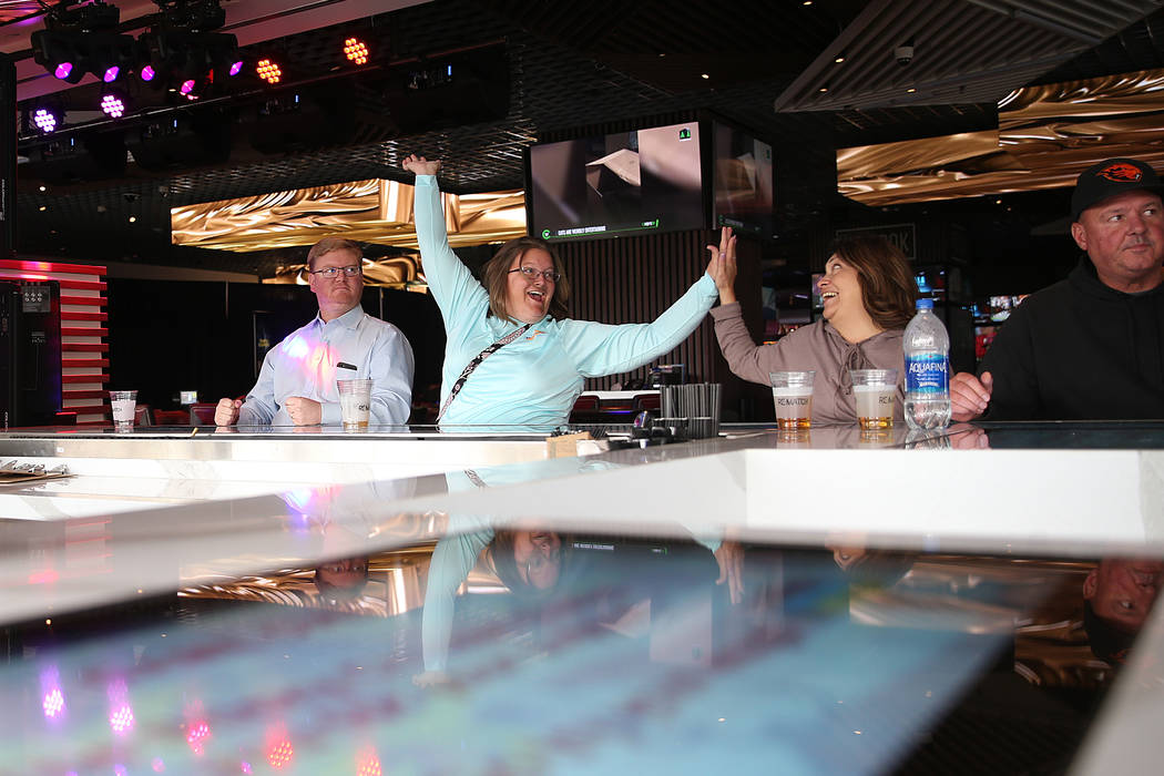 Jason Hessler, from left, looks on as his wife Marjorie, of Indiana, reacts after winning a bar ...