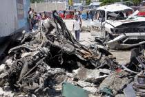 Somalis walk near the wreckage after a suicide car bomb attack in the capital Mogadishu, Somali ...
